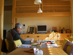 食卓でくつろがれるご主人。格子戸を通した光が入ります。